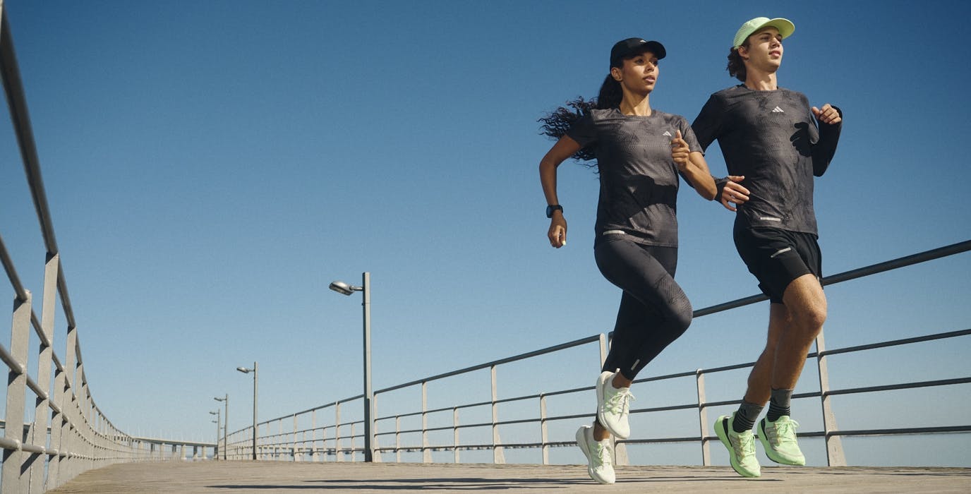 Woman and man running on a trail and wearing adidas apparel